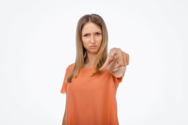 Senin hatandı. Hoşnut olmayan, sıradan elbiseli genç sarışın kadın kamerayı sana doğrultuyor, kızgın ve öfkeli. Stüdyo çekimi, beyaz arkaplan