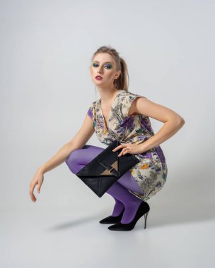 Stüdyoda poz veren çekici stil kızı. Model testleri. Canlı makyaj ve kıyafetler.