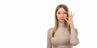 Sırların benim konseptimle güvende. Gündelik giysiler içinde sarışın bir kız fermuarlı jest yapıyor. Sanki anahtarı kapatıyor gibi. Stüdyo fotoğrafı, beyaz arka plan. Sır tut. İlan için yer