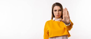 Hayır diyorum. Ciddi esmer kız avuç içini kameraya çekiyor, yasaklama işareti yapıyor, yasaklıyor ya da uyarıyor, dur işaretinde kolunu uzatıyor. Stüdyo beyaz arka plan çekti. Kopyalama alanı oluştur