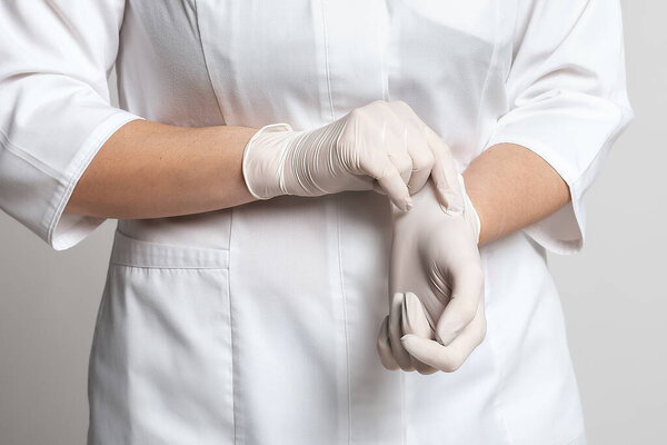 Обрезанный вид врача, надевающего белые латексные перчатки для защитного вируса. Защищайся. Медицина и здравоохранение