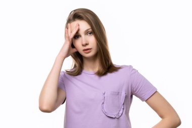 Pişman genç kadın hata yaptı. Hatalı olduğunu söylemek için eline tokat atan bir kız. Stüdyo fotoğrafı, beyaz arka plan. İnsani duygular, yüz ifadesi kavramı