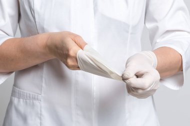 Kesilmiş doktor görüşü beyaz lateks eldivenleri çıkarır. Tıp ve sağlık hizmetleri kavramı