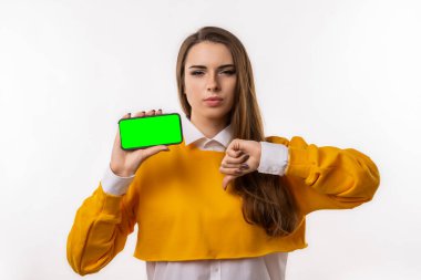 Bunu not al. Gündelik giysiler içindeki güzel esmer kadın elinde akıllı telefon boş ekranı gösteriyor. Kız yeni uygulama yüklemeyi önermiyor, online alışveriş sitesi