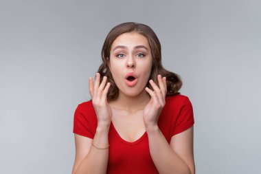 Şaşırmış genç esmer kadın bakışları ağzının açık kalmasına hayran kaldı. Şanslı iyi habere inanmadı. Şaşkın şaşkın baktı, nefes nefese kaldı, gri arka planda durdu.