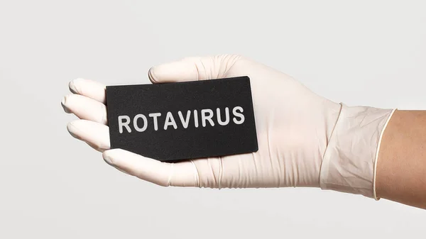 テキスト付きのカードを保持白い滅菌手袋で手の閉鎖 Rotavirus 医学的概念 — ストック写真