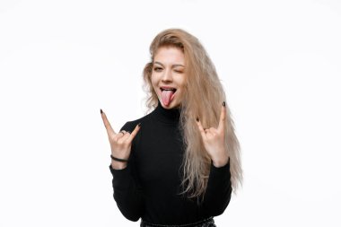 Rock n roll bebeğim. Ağır metal işareti ve dil gösteren, gündelik siyah giysiler içinde heyecanlı genç bir kadının portresi, parti yaparken ya da müzik festivaline katılırken evet diyor. Stüdyo çekimi, beyaz arkaplan