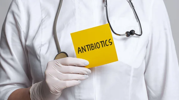 白いコートと滅菌手袋で医師の作物ビューは言葉でメモを保持 Antibiotics 医学的概念 — ストック写真