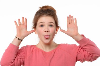 Komik surat yapan ve dilini gösteren neşeli genç kızın stüdyo portresi. Beyaz arka plan. İnsani duygular, yüz ifadesi kavramı