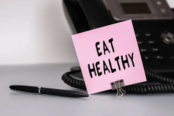Der Text Eat Healthy Steht Auf Einem Rosafarbenen Klebezettel Ein — Stockfoto