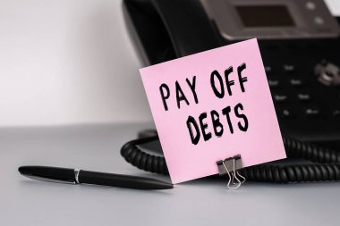 Mesaj, önemli bir olayı hatırlatmak için pembe yapışkan bir nota yazılmış borçları kapatıyor. Kişisel gündemimin kapanışı. Kavramsal fotoğraf