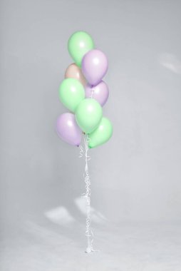 Stüdyoda beyaz arka planda renkli pastel balonlar var. Şölen dekoru. Kutlama zamanı.