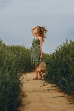 Genç bir kadın buğday tarlasında yürüyor, hayatın ve yazın tadını çıkarıyor. Buğday tarlası. Güneş ışığı altında güzel doğa manzarası. Sağlıklı yaşam tarzı kavramı. Gürültülü görüntü, film tahılı