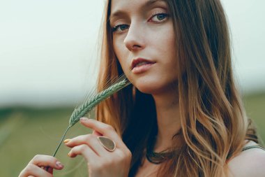 Gün batımında, uzun sarı saçlı, çok güzel, genç bir kadın. Sağlıklı yaşam tarzı kavramı. Gürültülü görüntü, film tahılı