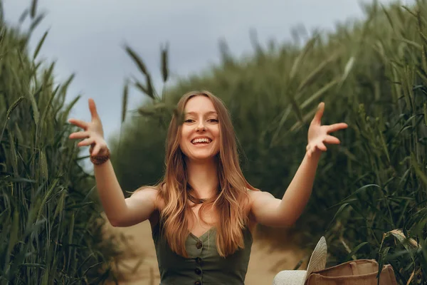 Genç bir kadın buğday tarlasında yürüyor, hayatın ve yazın tadını çıkarıyor. Buğday tarlası. Güneş ışığı altında güzel doğa manzarası. Sağlıklı yaşam tarzı kavramı. Gürültülü görüntü, film tahılı