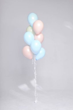 Stüdyoda beyaz arka planda renkli pastel balonlar var. Şölen dekoru. Kutlama zamanı.