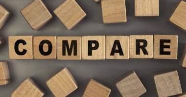 Masadaki küçük tahta bloklarda COMPARE kelimesi. Kavramsal fotoğraf. Üst görünüm