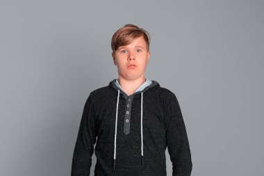 Şok olmuş komik bir çocuğun portresi. Genç çocuk ağzını geniş bir şekilde açıyor, şaşırtıcı beklenmedik haberlerle şoke olmuş, hayret verici bir bakışla, tam bir inançsızlık gösteriyor.