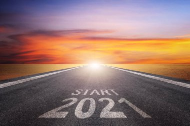 Asphalt yolu üzerinde ok kılavuzu ve 2021 harfli ve yüzeyinde START harfleri var. Gelecekteki amaçlar ve zaman geçirmek için başarı kavramı. Mutlu yıllar.