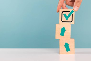 Onayla, doğru karar, işaretle ve listele konsepti. Bir adam onay için işaretli tahta küpleri yerleştiriyor veya kopya alanı ile karar veriliyor