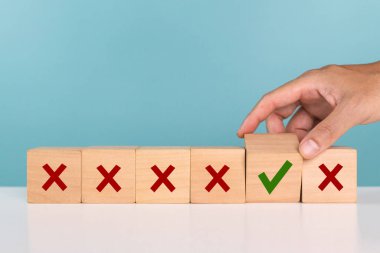 Bir Adam kırmızı haçlı çoklu kutulardan yeşil işaretli onay kutusunu seçer. Seçim stratejisi, olumlu ya da olumsuz, karar, kabul ve düşüş