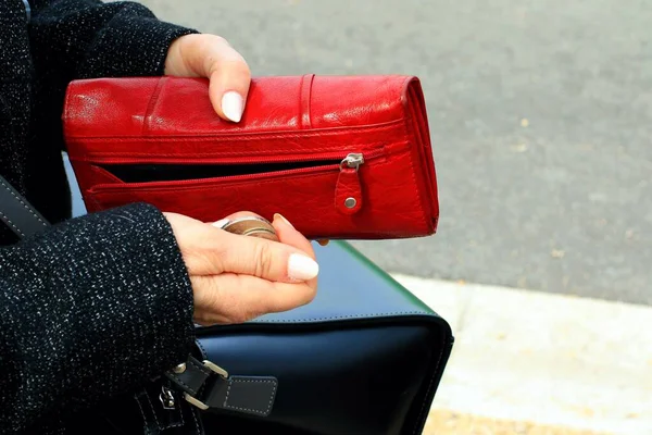 Woman with a red purse. Woman hold leather wallet. Black bag and red wallet.