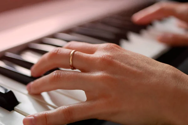 Woman musician hands playing piano keyboard, MIDI synthesizer, home music learning.