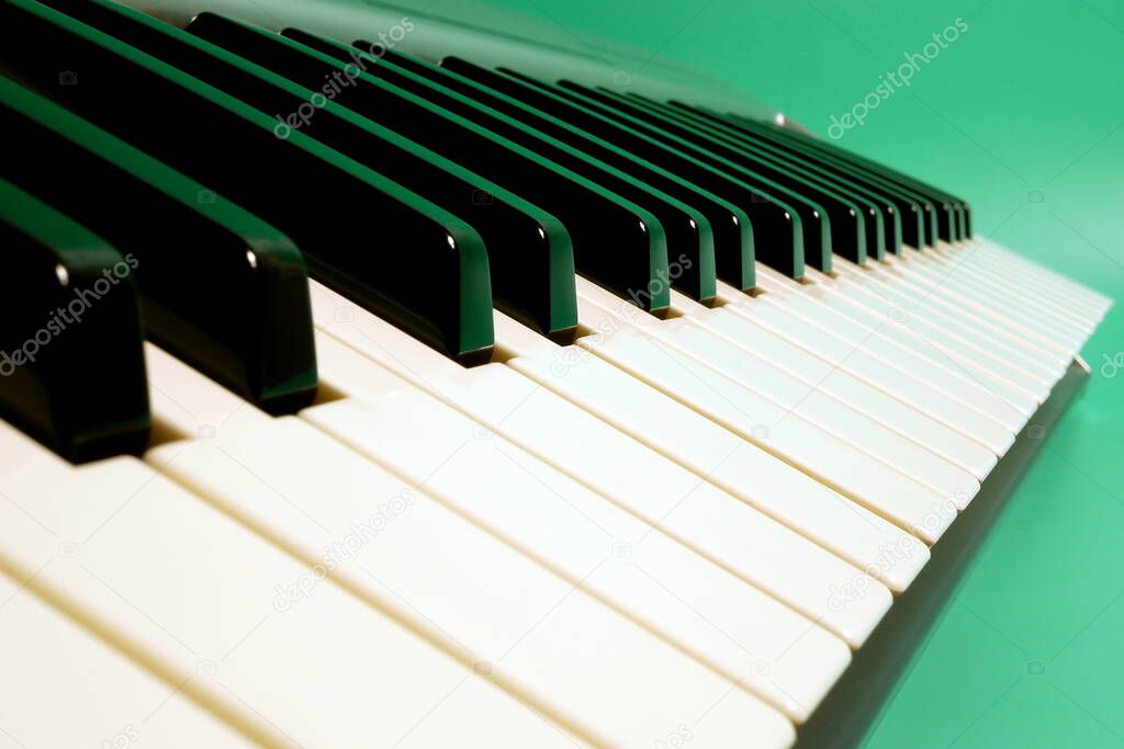 Close up of musical keyboard synthesizer on turquoise background. Focus on the middle ground.