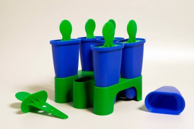 Gri arka planda ev yapımı dondurma yapma formları. Yeşil kapaklı mavi dondurma konserveleri. 