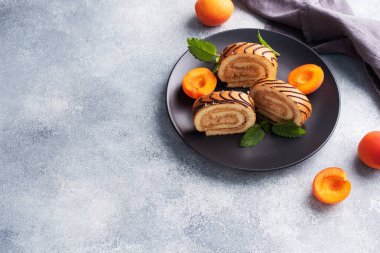 Kremalı çörekler tabakta. Taze kayısı çileği ve nane yaprağı.