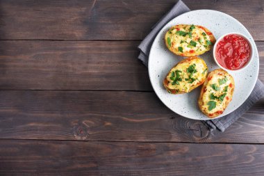 Peynirle doldurulmuş kabukta fırında patates sarımsak ve otlarla dolu.