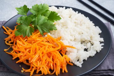 Beyaz haşlanmış pirinç ve baharatlı Kore havuç salatası.