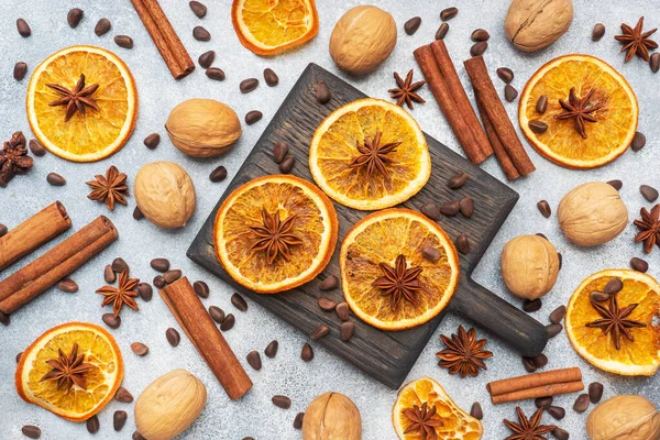 Christmas composition with dried oranges, cinnamon, anise and nuts on a gray concrete background. Flat lay top view