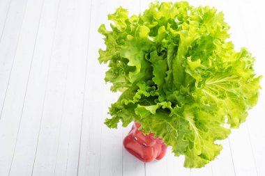 Beyaz bir masada, Hippo şeklinde bir kupa içinde bir sürü marul yaprağı. Boşluğu kopyala