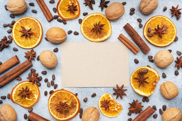Christmas composition with dried oranges, cinnamon, anise and nuts on a gray concrete background. Flat lay top view Copy space