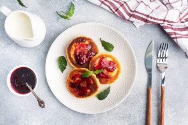 Yabanmersini reçelli süzme peynirli börek. Peynirli peynirli kekler, gri beton arka planda krepler. Boşluğu kopyala