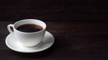 Beyaz seramik fincanda koyu espresso kahvesi. Tahta koyu arkaplan, boşluğu kopyala
