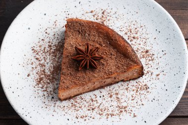 Tabakta bir dilim çikolatalı güveç, çikolatalı ve kahveli bir parça kek. Koyu ahşap arka plan