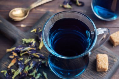 Thai blue tea anchan of buds klitoria Ternate in a glass cup, dark background