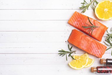 Somon fileto, beyaz masada kırmızı tuzlu balık. Limon, biberiye baharatları Boşluğu kopyalayın.