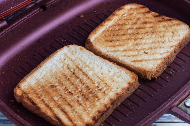 Izgara tavada iki parça kızarmış ekmek. Kapat.
