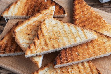 Kesme tahtasındaki sandviçler için bir dilim çıtır ekmek, ahşap bir arka plan. Kapat.