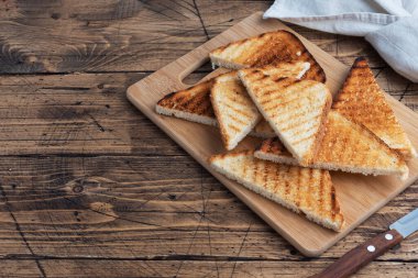 Kesme tahtasındaki sandviçler için bir dilim çıtır ekmek, ahşap bir arka plan. Boşluğu kopyala
