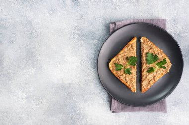 Sandviçler çıtır çıtır tost ve maydanozlu tavuk ciğeri ezmesi gri beton bir masada siyah bir tabakta. Boşluğu kopyala.