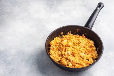 Lezzetli Asya pilavı, sebzeli pilav ve tavuklu kızartma tavası. gri beton arka plan. Boşluğu kopyala