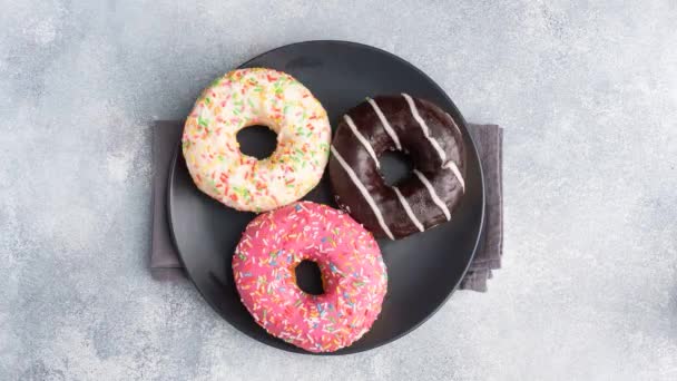 Detener el movimiento de rosquillas vidriadas en una vuelta de plato. Vista superior. El concepto de comida alta en calorías. — Vídeo de stock