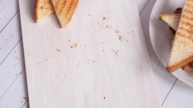 Sandviç yapmak için kesme tahtasına kızarmış ekmek konur..
