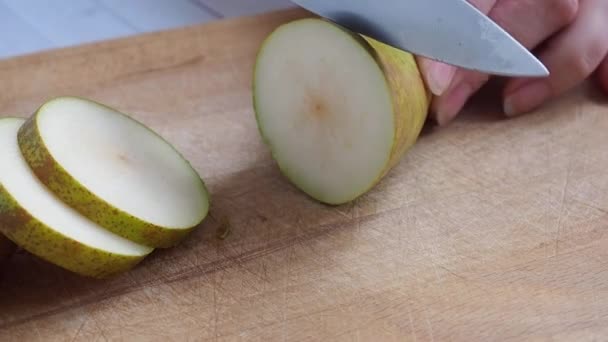 木の板の上でナイフで切った熟した梨の会議. — ストック動画