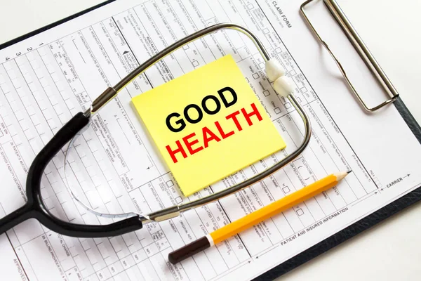 Text Good Health on a yellow sticker with a stethoscope lying on a folder with medical documents. Can be use as concept photo