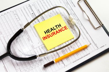 Tıbbi belgelerle dolu bir klasörün üzerinde steteskop bulunan sarı bir çıkartma için Helth Sigorta 'ya mesaj at. Konsept fotoğraf olarak kullanılabilir